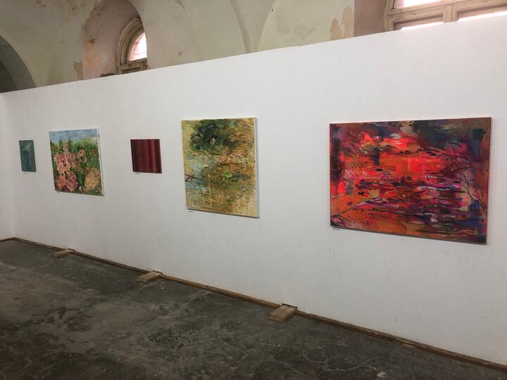 Succesiune de picturi contemporane expuse pe un panou alb