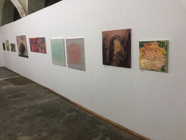 Șir de lucrări contemporane pe peretele alb al galeriei