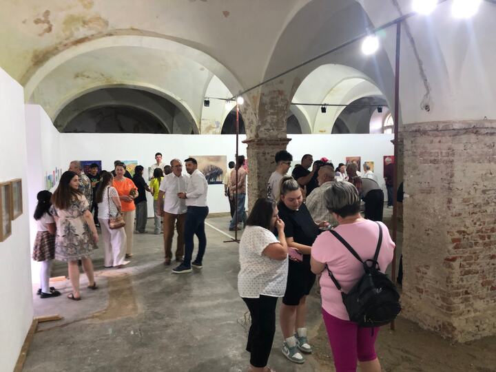 Vizitatori reuniți în interiorul galeriei la inaugurare