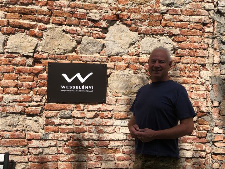 Portret în fața zidului istoric și a siglei WESSELÉNYI